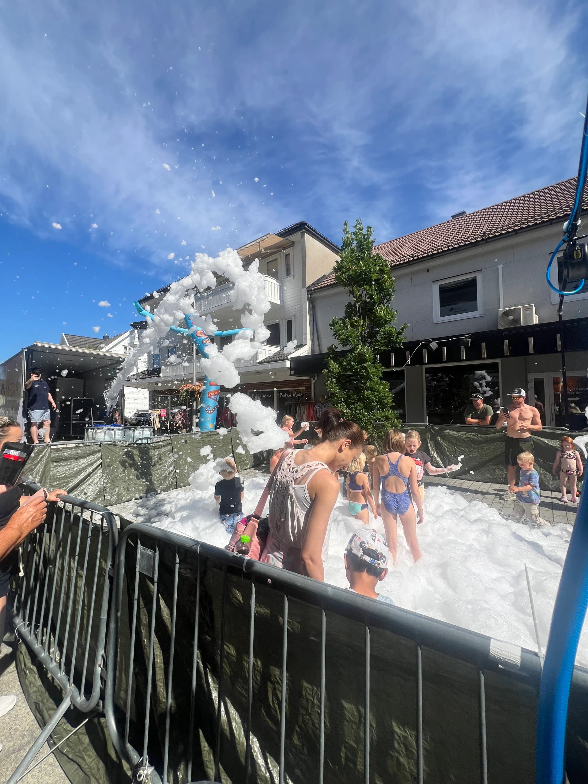 Barn og foreldre leker i skumbinge på et sommerarrangement